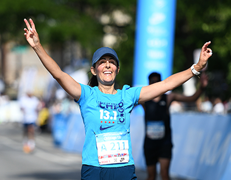 Woman running with arms raised