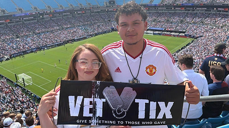 Couple smiles with Vet Tix Banner