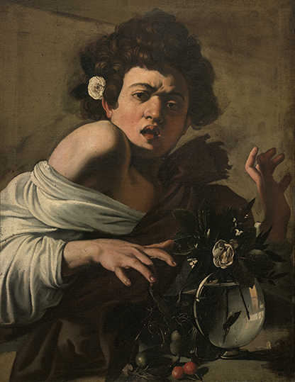 Young curly-haired figure in a Baroque painting leans over a table with a small vase of flowers and fruit, lit against a dark background.