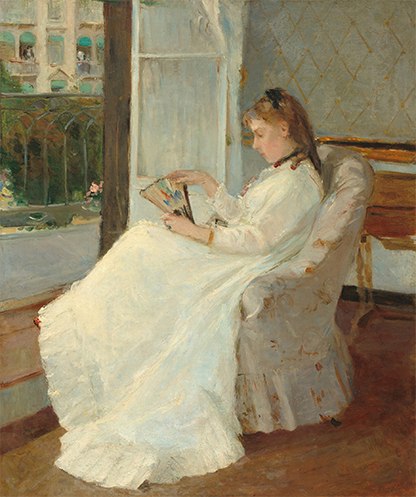 A person sitting in a chair reading a book 
