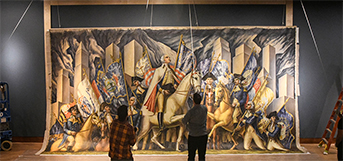 Large historical mural being installed on a museum wall with two people adjusting it