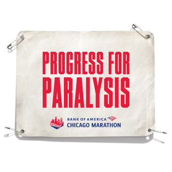 An image of a bib that says “Progress for Paralysis”