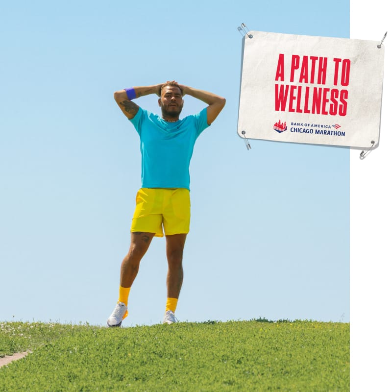 Everett standing outdoors in running gear, with an image of a bib that reads “A PATH TO WELLNESS”