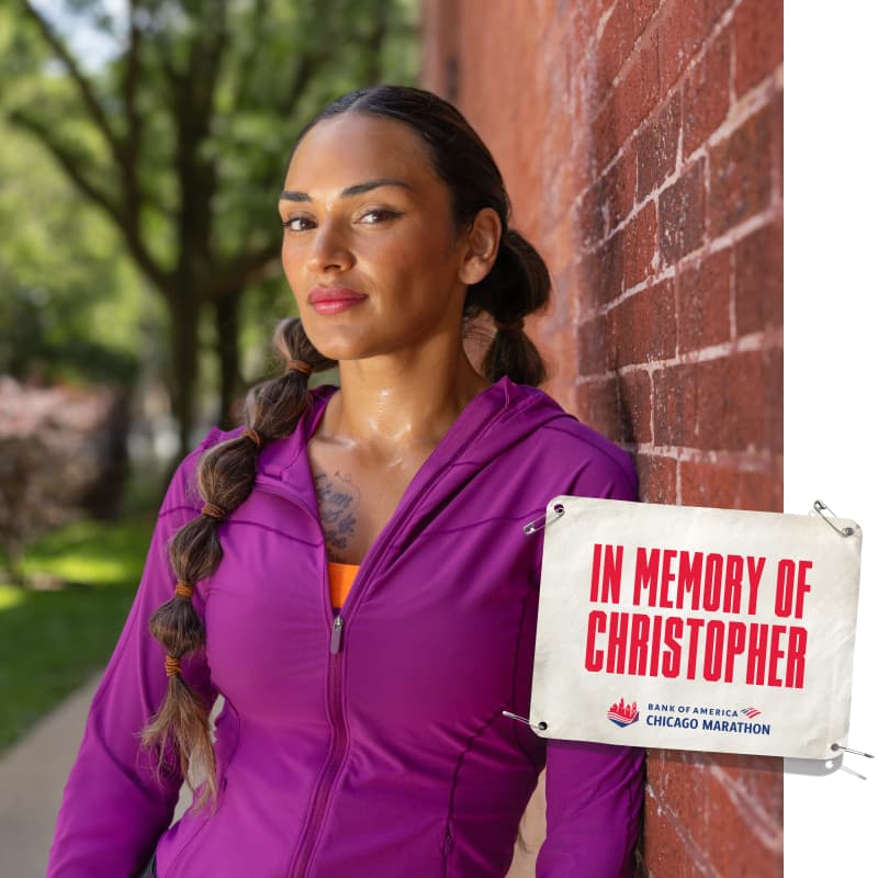 Isabel running with an image of a bib that reads “IN MEMORY OF CHRISTOPHER”