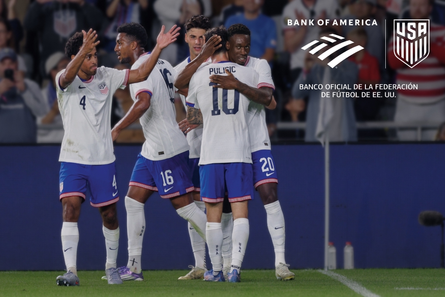 Jugadores de fútbol profesional se abrazan y celebran en el campo