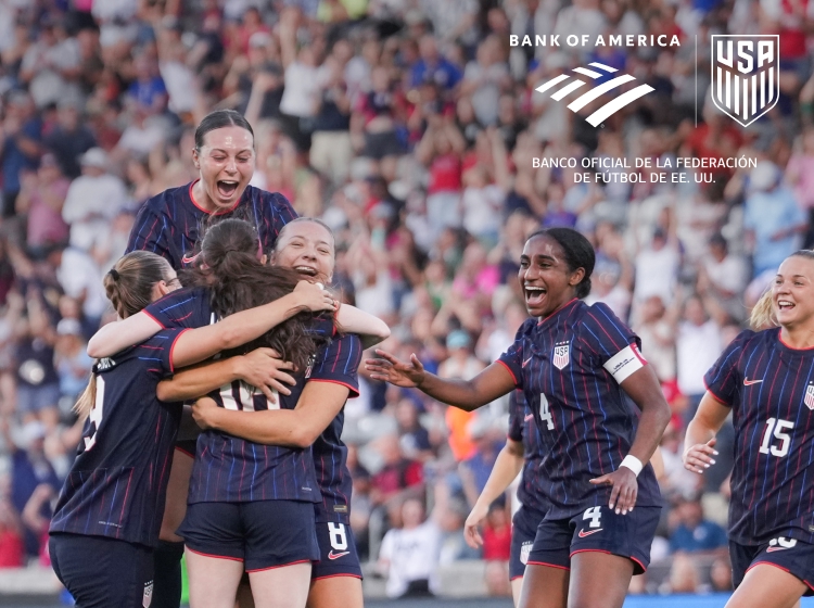 Fotografía de un grupo de futbolistas femeninas celebrando en un campo.