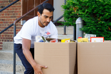Volunteer lifting boxes of food