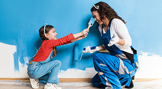 Mother and daughter painting wall