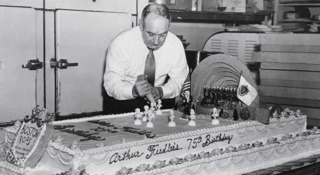 Man decorates cake in bakery