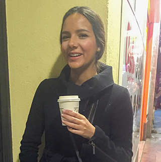 Carolina Ferreira smiles while enjoying a cup of coffee