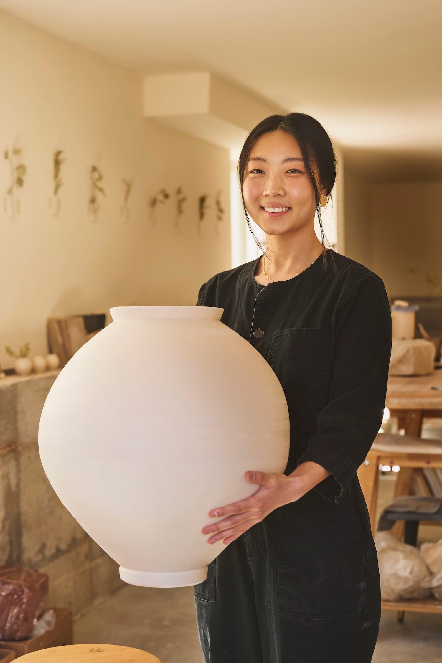 Judy Suh, Ceramic artist & small business owner of Jay Ceramic, showcasing a piece of her work 