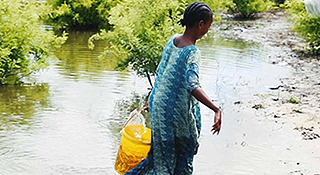 Woman carrying bucket of water