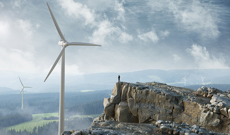 Vast mountainscape with several windmills and a person looking out, standing at the edge of a cliff.