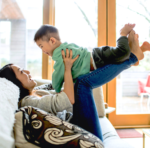 Woman and child playing on a couch