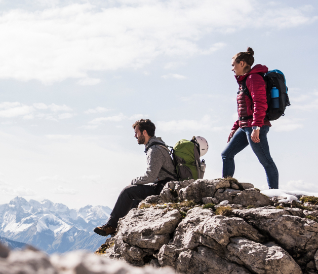 Two people climbing a mountain