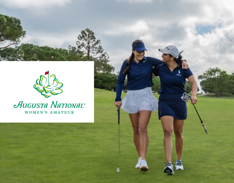 Two female golfers smiling while walking on a golf course. They have their arms wrapped around each other's shoulders.