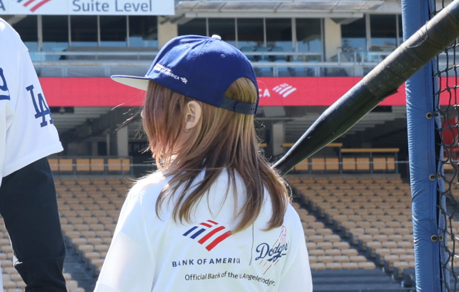 A young girl baseball player waiting to swing at a pitch