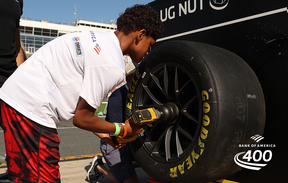 Child fixing tire on race car