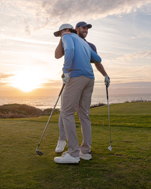 Two brothers, known as the Bryan Bros, hug each other on a golf course.