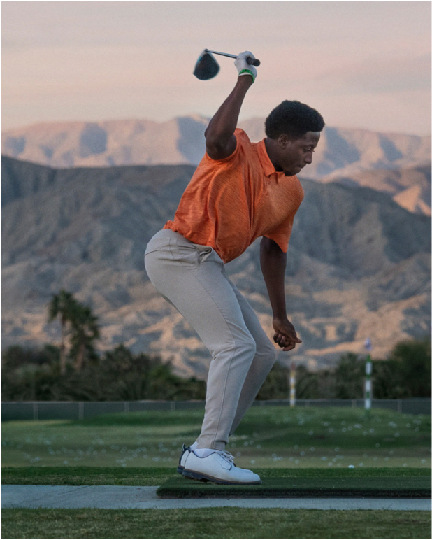 A male golfer, known as Snappy Gilmore, practicing his famous, one-armed swing on a driving range.