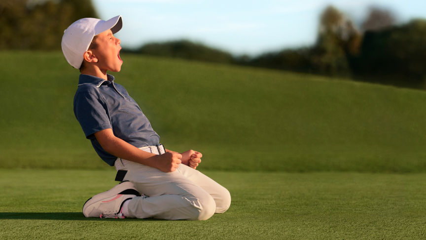 A young golfer celebrates his great shot