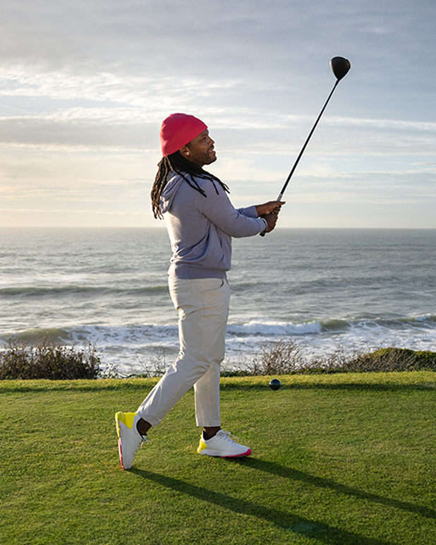 A male golfer, Will Lowery, swings a golf club on a golf course.