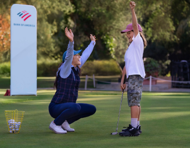 Woman golf instructor celebrating with a young girl golfer