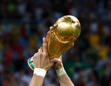 Hands raising the World Cup trophy in victory