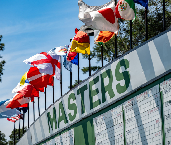 International flags waving atop the leaderboard at the Masters Tournament