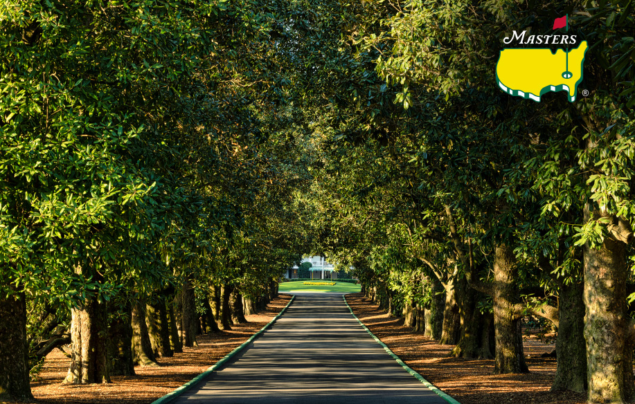 Sunlight filters through the magnolias of the iconic Magnolia Lane featuring the Master’s Tournament logo in the top right corner