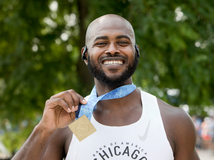 Male runner smiling with medal