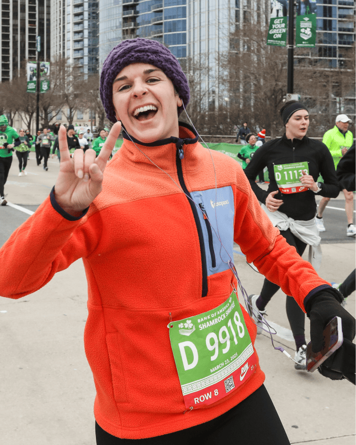 An athlete in an orange fleece excited to be running the Shamrock Shuffle