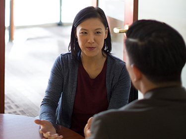 Man and woman talking at a table.