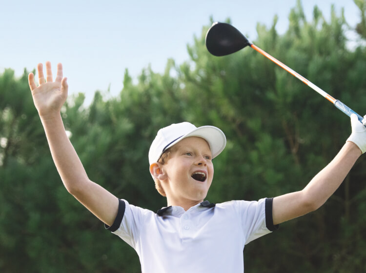 A young boy celebrating a golf shot 