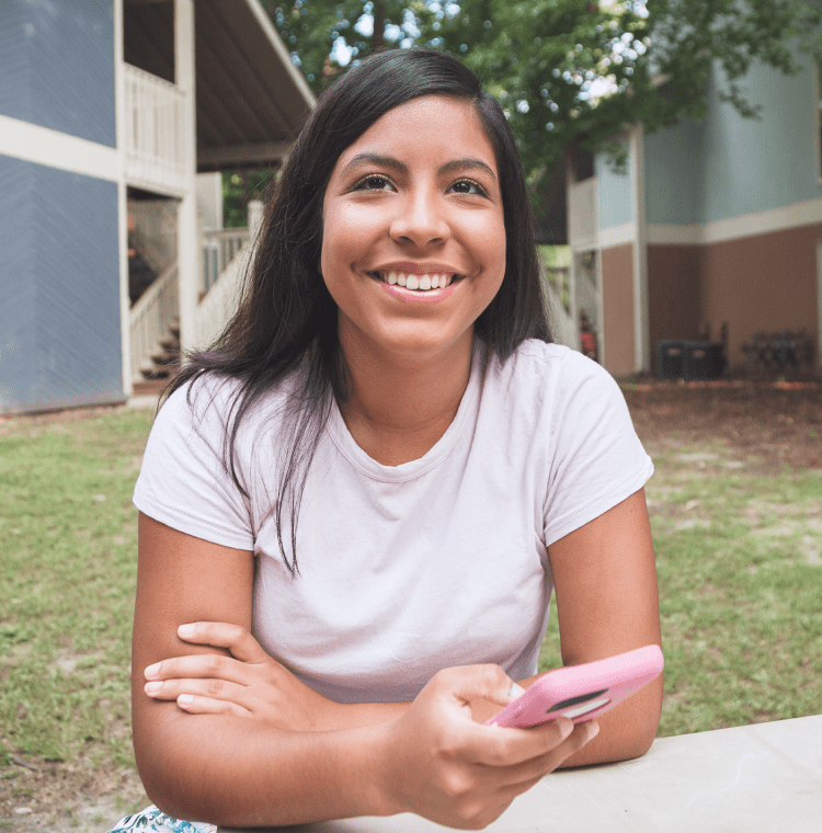Woman smiling outside apartment complex