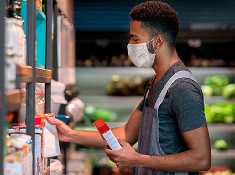 Volunteer stocking shelves with face mask on