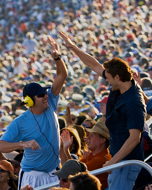 Two fans high-fiving in the stands
