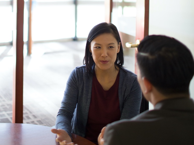 Two people talking at desk