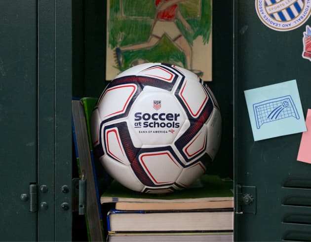 A soccer ball with the Soccer at Schools logo in a school locker