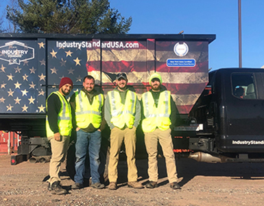Four men standing in front of truck