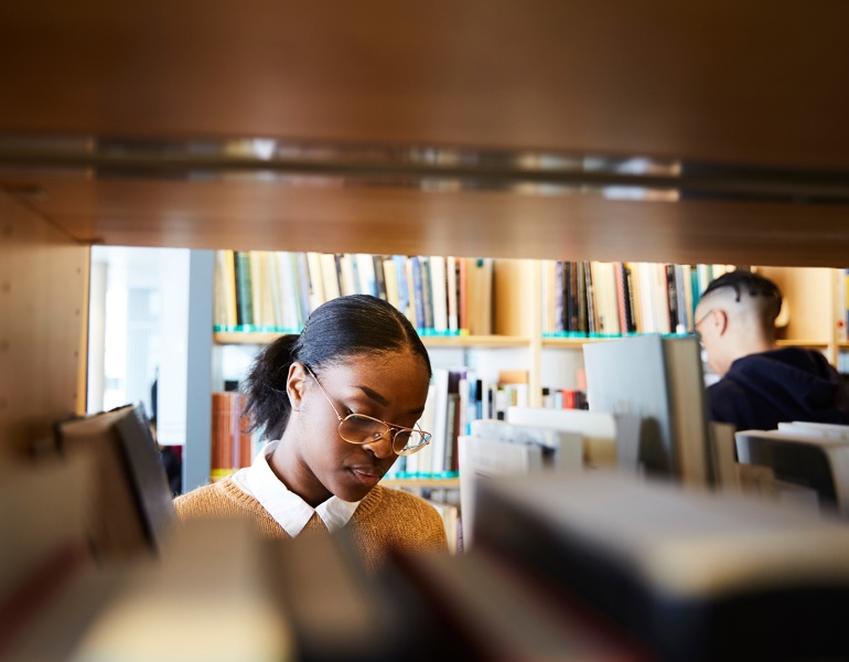 student looking for a book in library