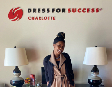 Woman smiling under 'Dress for Success' sign