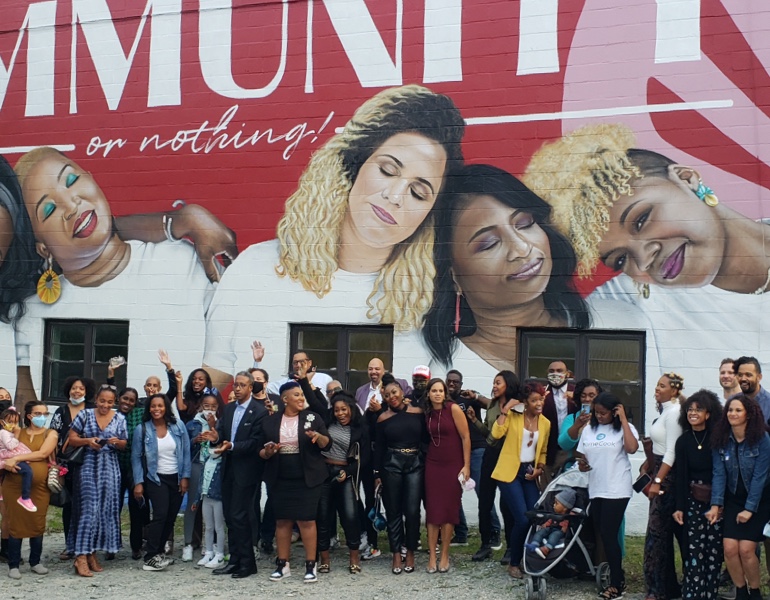 Large group of people in front of mural