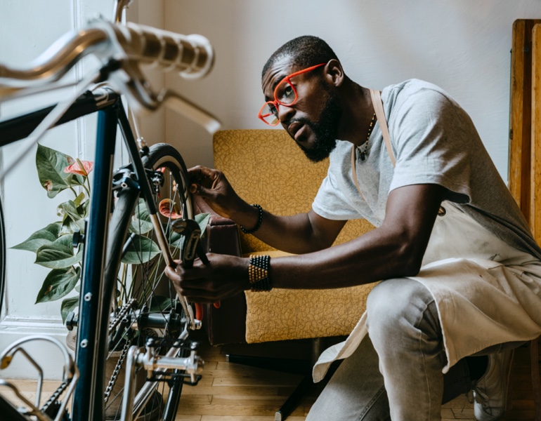 African American man working on bicycle