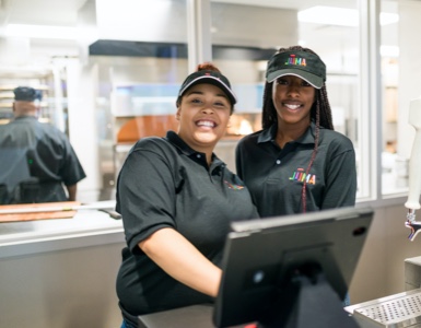 Two workers behind the counter, smiling