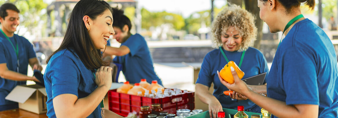 Volunteers sorting fresh produce and supplies at a community event.