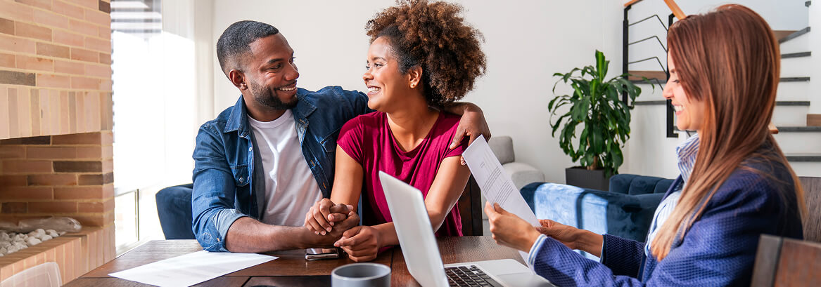 Couple meeting with a financial advisor at a desk.