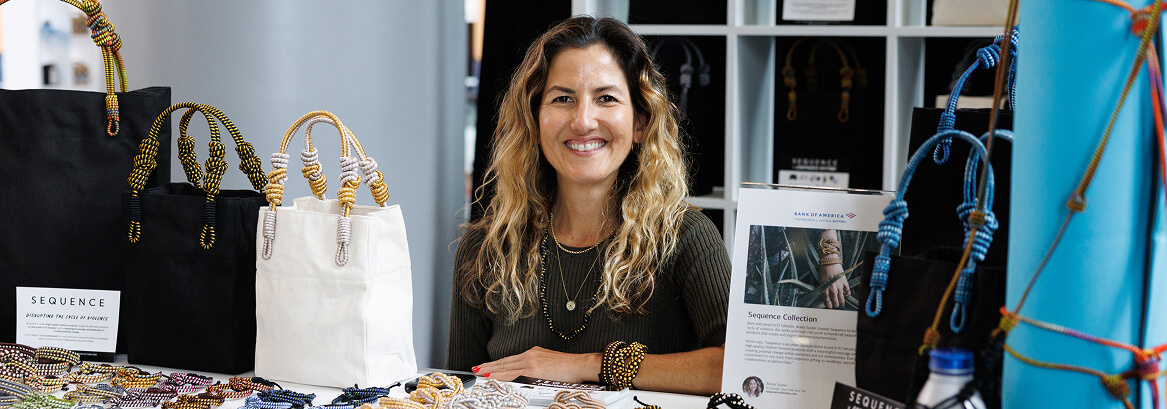 Small business owner displaying handmade products at a market booth.